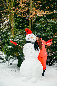 妇女穿着红色帽子和手套用雪图片