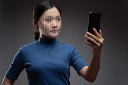 使用面部识别系统用智能电话扫描亚洲女脸部图片