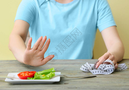 缺乏经验的妇女拒绝在餐桌上吃蔬图片