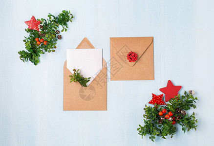 质朴的木制蓝色背景与圣诞空白卡和工艺信封环保装饰的想法平躺图片