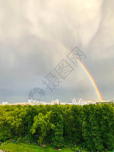 明亮的彩色虹在天空中雨后城市出现了一道不同颜色的双彩虹一种美丽而浪漫的自然现象雨滴背景图片