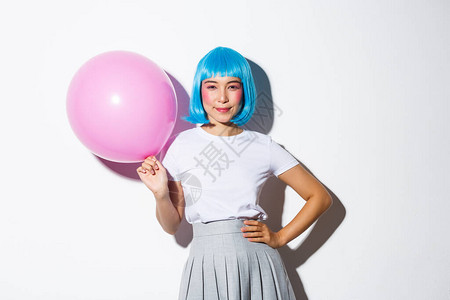 穿着蓝假发穿衣服参加派对拿着大粉色气球对着镜头满怀自信地微笑的雅图片