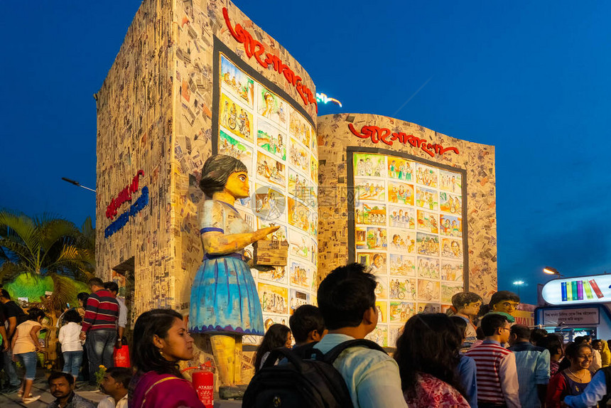 一个女孩的大雕塑和她的书籍在加尔各答书展上出图片