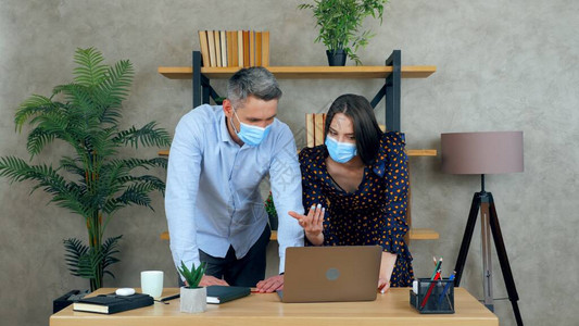 聪明的女人和男人在办公室里一起工作的员工脸上戴防护医用口罩图片