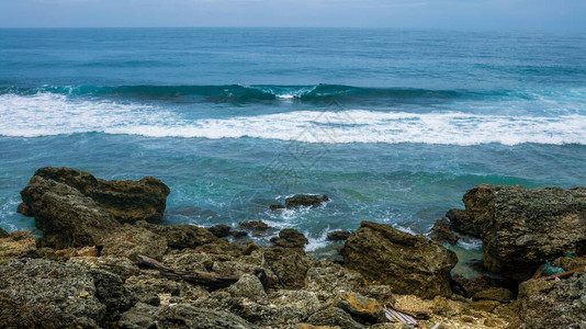 海浪滚向与海岛岸的海洋岩石自然背景场的海景在海滩的美丽海图片