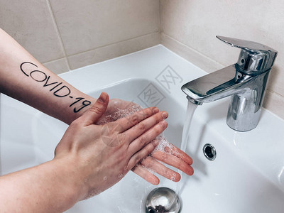 妇女用COVID19的刻画手洗在白浴缸里图片