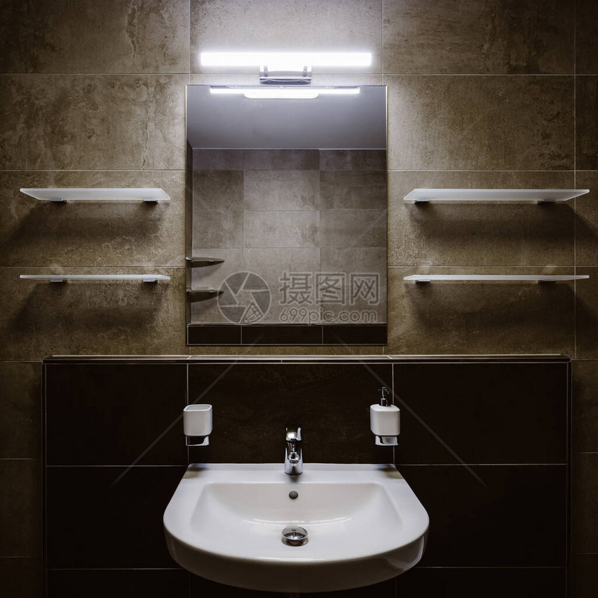 浴室用白色洗手盆和铬水龙头以对称形状铺设的墙壁图片