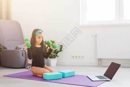 在家里隔离小女孩在隔离期间做瑜伽图片
