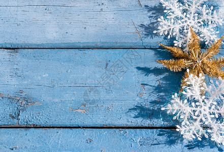 美丽的蓝色圣诞水平背景与白色雪花和金色闪亮的星图片