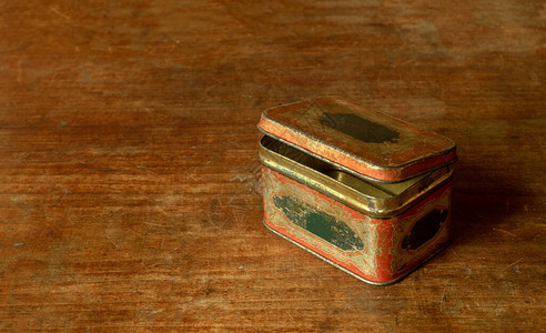 木桌上的旧金属茶盒图片