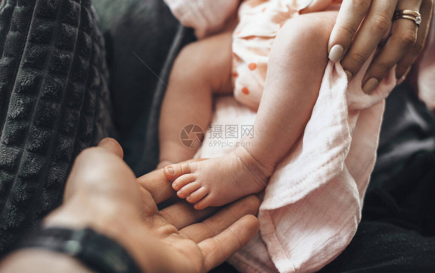 新生儿双脚和父母抱住她的近视相片图片