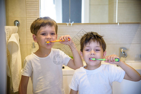 双胞胎孩子蹒跚学步的男孩兄弟姐妹在浴室厕所洗脸手刷牙用刷玩水图片