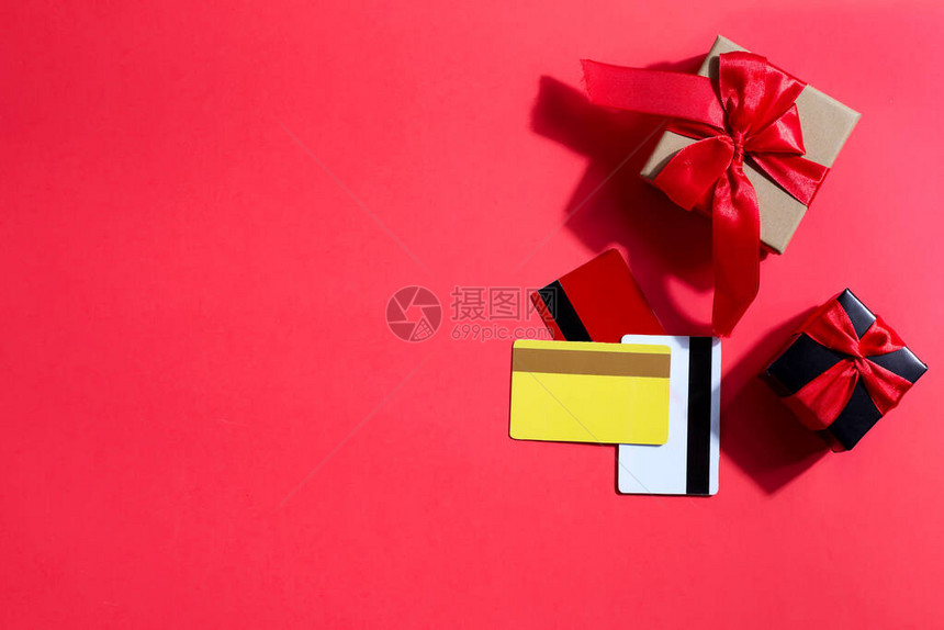 假礼品纸盒和信用卡或红背景的彩色折价卡复制空间顶级视图黑色星图片