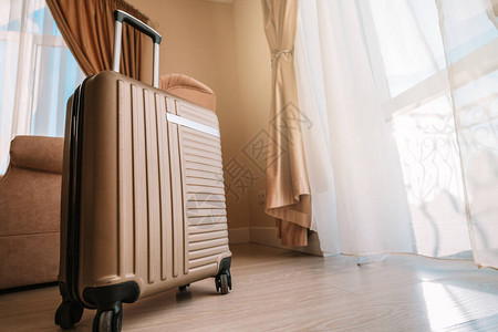 旅行李箱站在一个白色干净的旅馆房间里图片