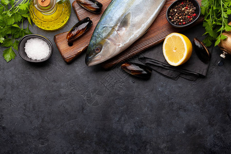 生鱼烹饪海产食品和在石桌边吃晚餐的食料图片