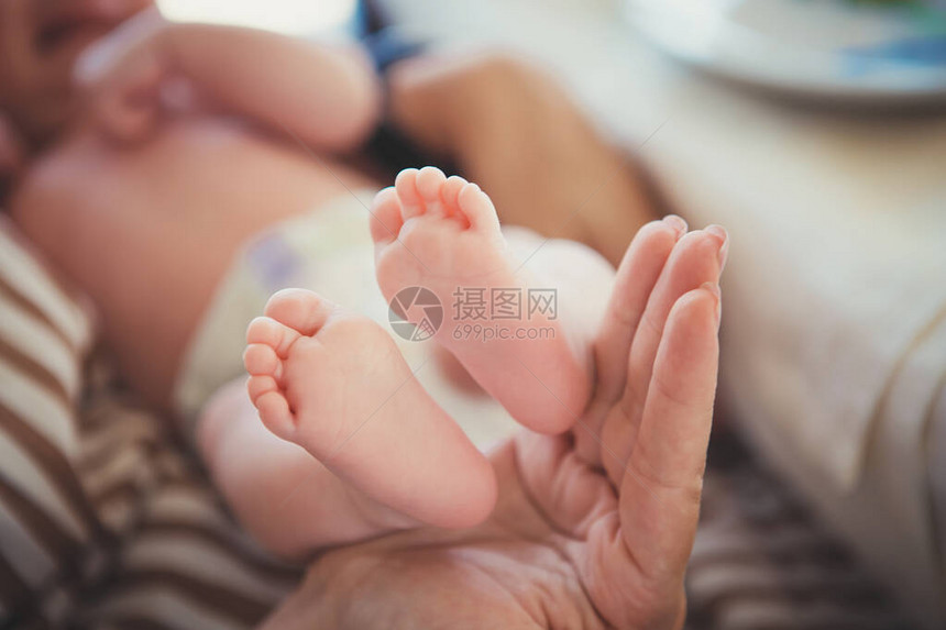 婴儿的脚在母亲手中妈和她的孩子幸福家庭的概念美丽的孕产概念形象妈把孩子抱在手里女人双手抱着刚图片