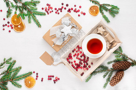 自然圣诞节装饰茶杯Xmas礼品红莓松果和白木背景的树枝图片