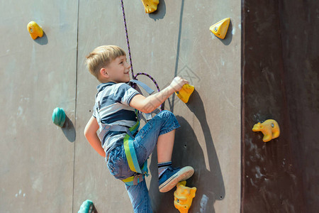 一个男孩在攀爬设备了人造塔顶在体育极乐娱公园图片