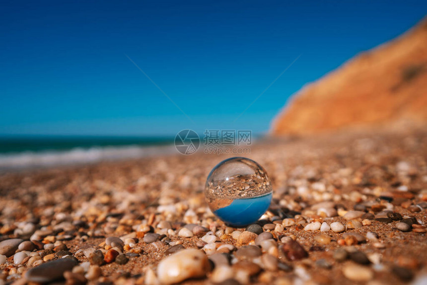 与通过水晶球拍摄的大海的滩球中的图片清图片
