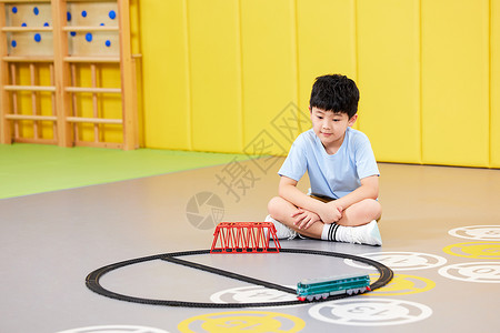 室内玩玩具火车的小男孩背景图片