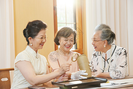 老年女性聚会鉴赏古董图片