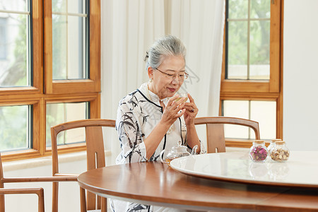 高品质生活喝茶的老年优雅女性背景