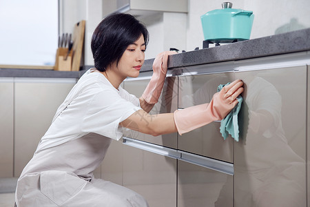 蹲着洗碗女人打扫厨房的居家女性背景