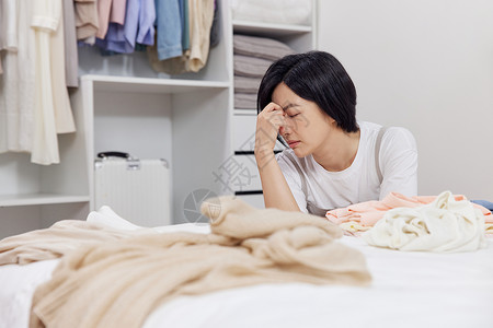 收拾衣物感到烦躁的居家女性背景图片