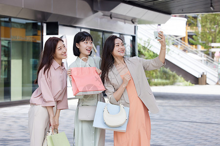 姐妹合照逛街购物的女性使用手机合照背景