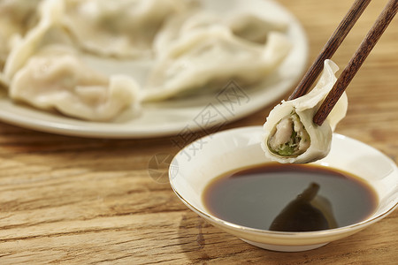 新鲜水饺筷子夹起水饺蘸醋特写背景