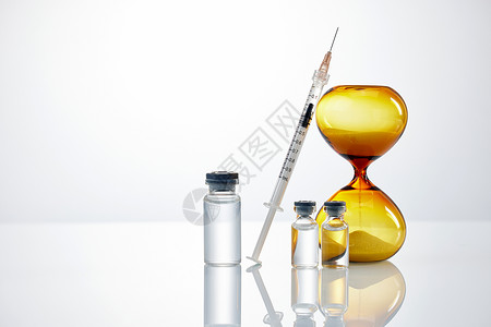 沙漏与医疗疫苗针剂背景图片