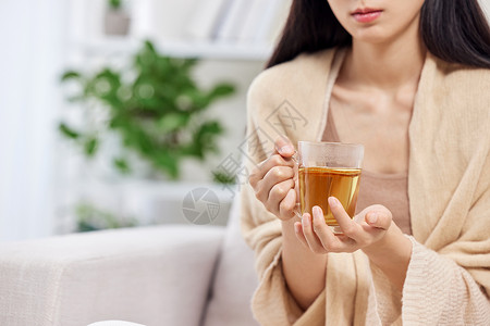 冬季保暖喝姜茶的女性特写背景图片