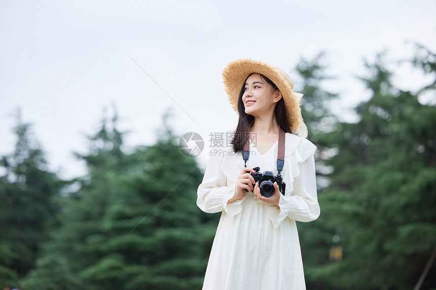 青年文艺美女手拿相机拍照图片