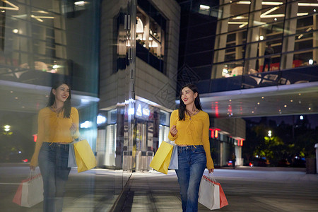 年轻美女在夜晚购物逛街图片