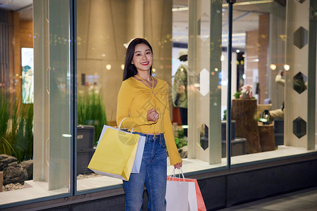 年轻美女夜晚逛街购物背景图片