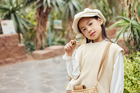 棕榈在西海岸在植物园手拿放大镜的小女孩背景