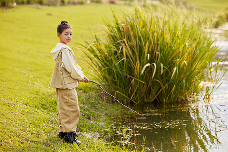 小女孩室外使用鱼竿钓鱼图片