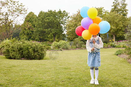 户外手拿气球的可爱小女孩形象图片