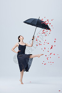 青年美女撑伞舞蹈花瓣飘落图片