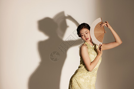 手拿扇子起舞的国潮女性背景图片
