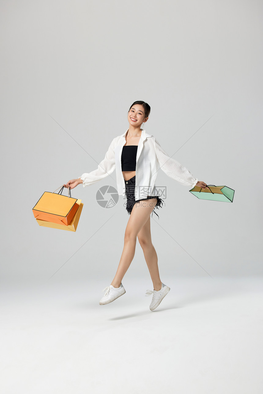 手提购物袋的女性舞者图片