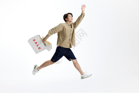 跳跃的男性手提购物袋图片