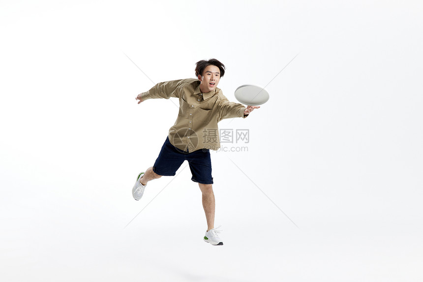 青年男性跳跃玩飞盘形象图片