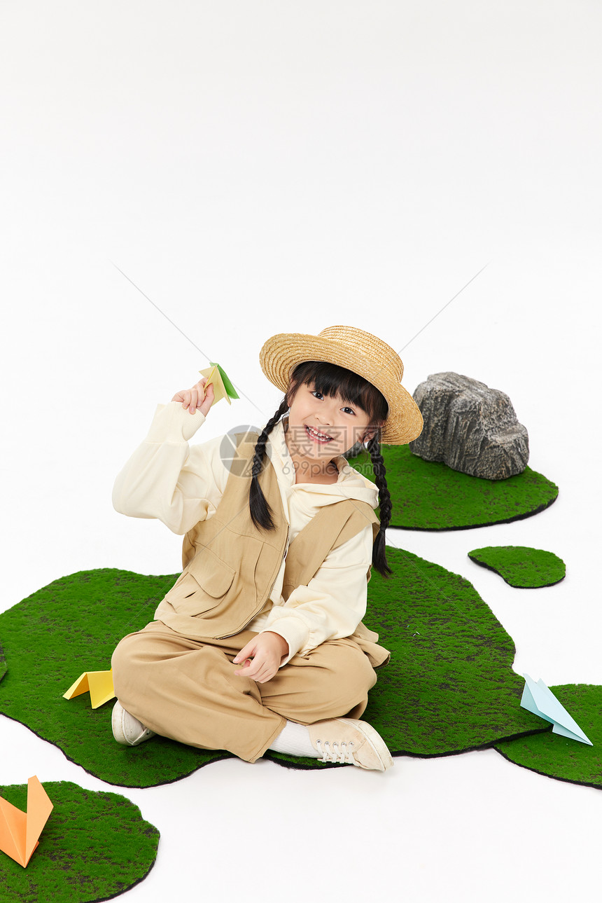 可爱女孩在草地上飞纸飞机图片