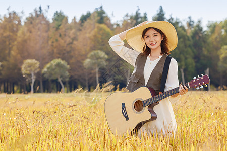 在稻田里弹奏吉他的美女图片