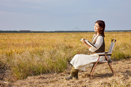 秋季在稻田里写生的美女图片