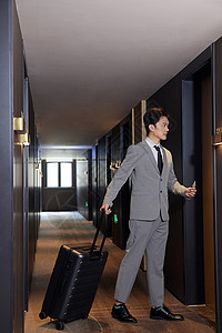 外地出差的商务男士酒店入住行李箱高清图片素材