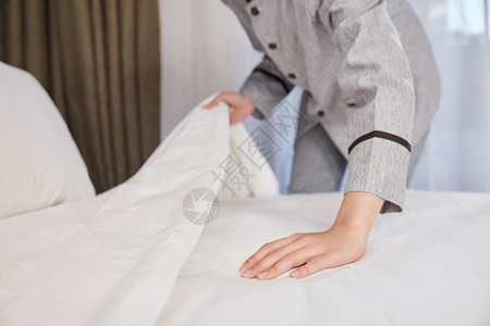 客房特写酒店管理保洁员整理床铺特写背景