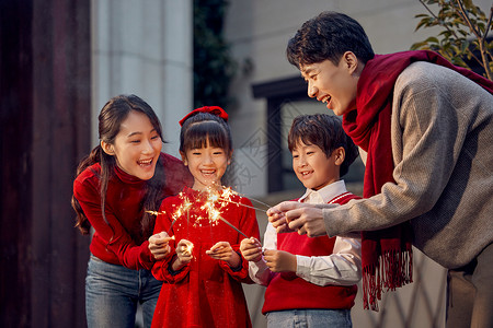 春节女人幸福一家人春节在院子里放烟花背景