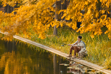 在公园湖边钓鱼的父子高清图片